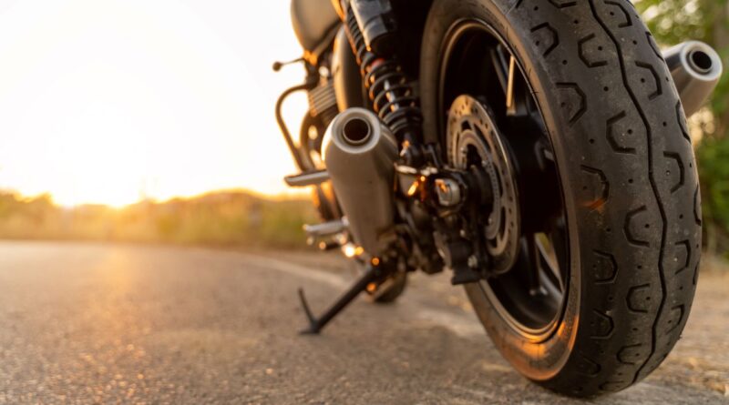 Nahaufnahme eines Motorrads auf der Straße bei Sonnenuntergang – Tipps für optimalen Motorrad Schutz gegen Wetter und Schäden.